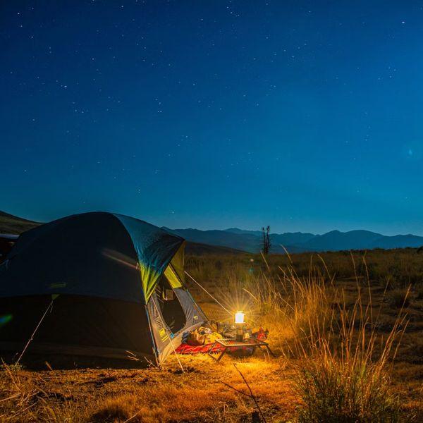 camping lantern outside tent under stars