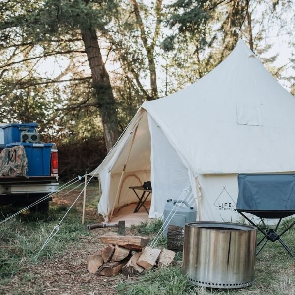 canvas overland ground tent with tent gear accessories next to rig