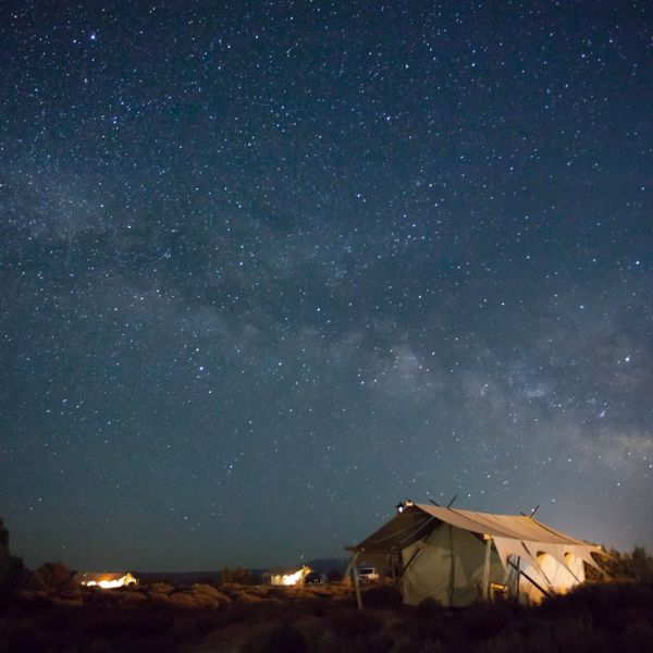 canvas wall tent under starry dark skies