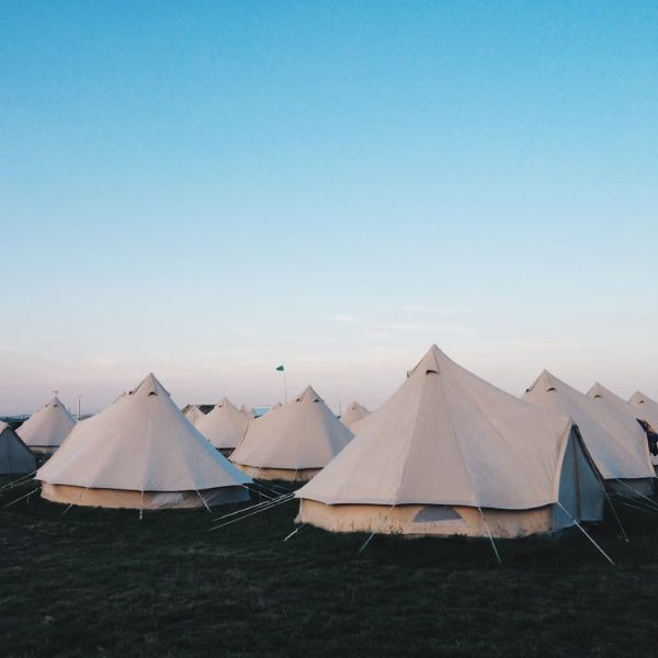 bell tents under bright blue sky