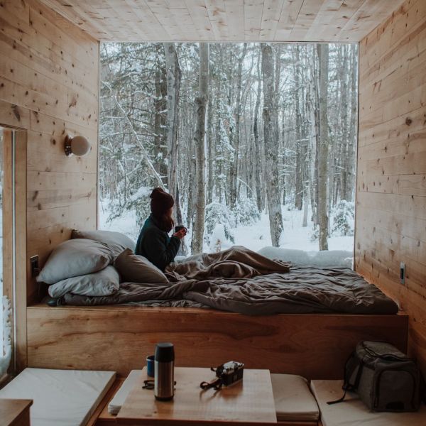 woman with coffee in winter glamping cabin