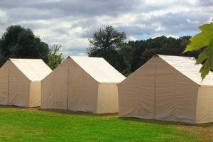 3 wall tents side by side on grass with tree background