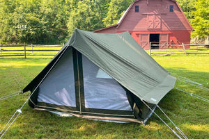 camping tent in front of red barn